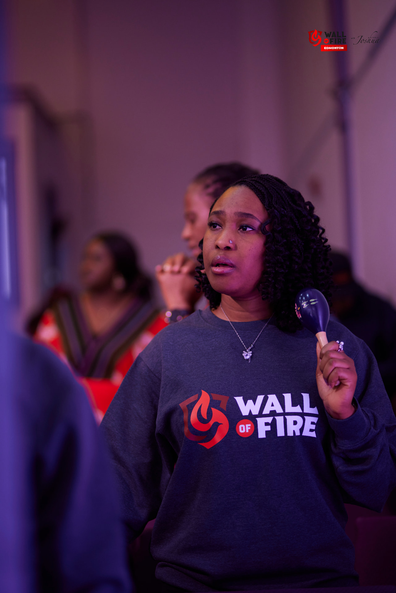 A worshipper lifting hands in the fire light